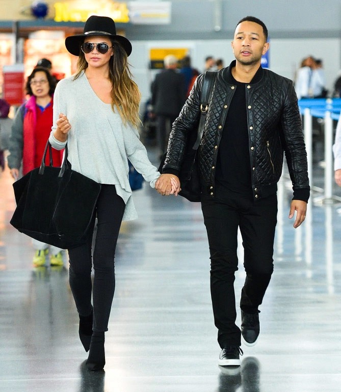 Siêu mẫu Chrissy Teigen chọn bộ trang phục giản dị, áo len dáng rộng kết hợp với quần jeans đen, boot thấp cổ kết hợp với mũ pandora màu đen và phá cách với kiểu kéo trễ một bên vai áo cho thêm phần sexy. (Ảnh: SPLASH NEWS ONLINE)